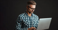 Illustration explicative d'un homme portant des lunettes et une chemise à carreaux, utilisant un ordinateur portable dans un contexte éducatif ou professionnel.