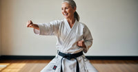 Art martialiste en kimono blanc pratiquant le karaté, illustrant les réflexes pour prévenir les douleurs articulaires chez les sportifs.
