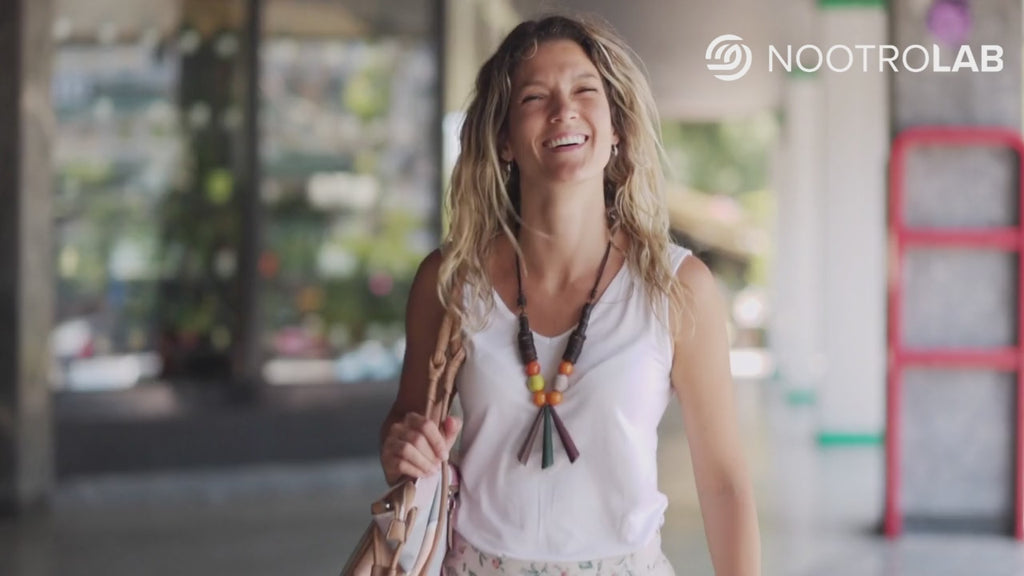 Jeune femme souriante avec écouteurs et sac à main